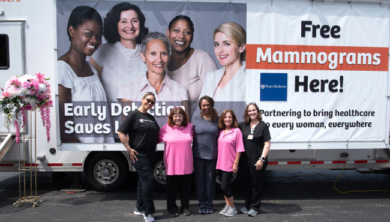 Five members of the Penn Medicine Health Education, Screening, and Community Health Fair Team stand in front of a mobile screening program.